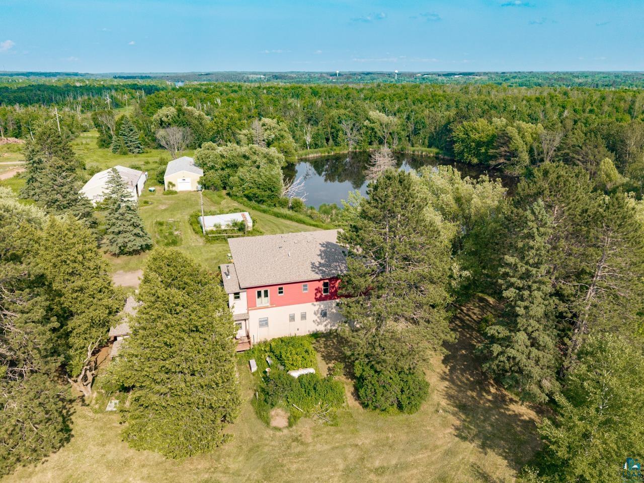 4800 Tower Road Moose Lake, MN 55767 - Photo 34 of 83 Aerial property view featuring a two-story residence with a red upper facade and light-colored lower level, set amidst mature trees