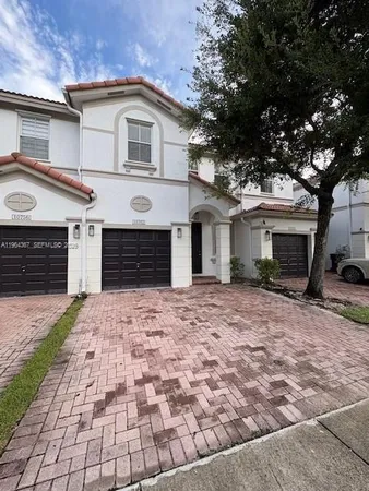 a front view of a house with a yard and a garage