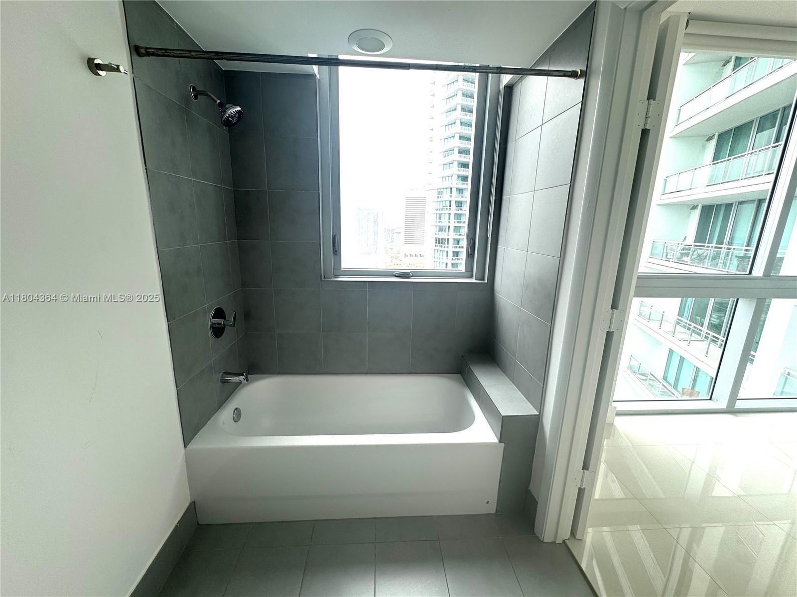 92 Southwest 3rd Street, Unit 1605 Miami, FL 33130 - Photo 20 of 21 a white bath tub sitting next to a window