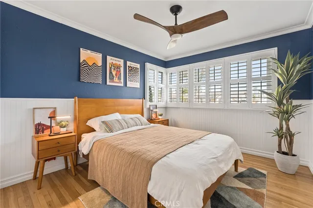 a bedroom with a large bed a chandelier and a potted plant