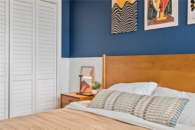 a bedroom with a bed and a painting on the wall