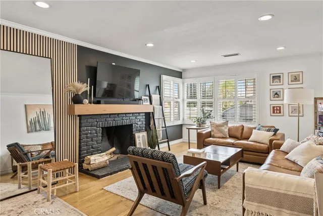 a living room with furniture fireplace and a large window