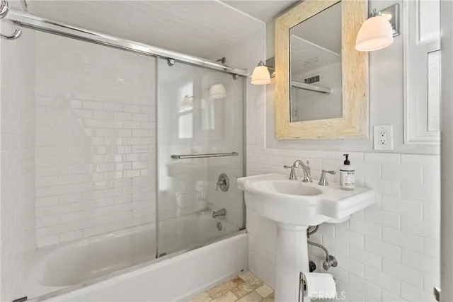 a bathroom with a sink shower and a mirror