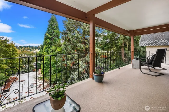 a view of a patio with couches table and chairs potted plants with wooden floor and fence