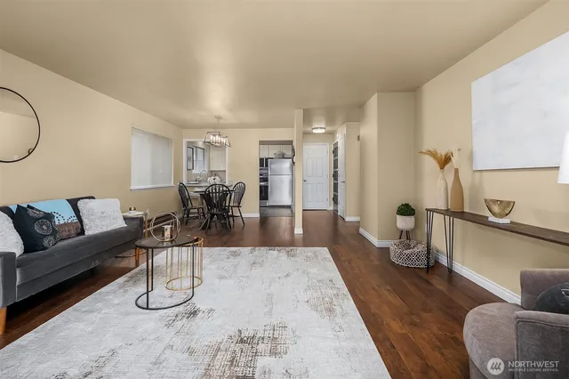 a living room with furniture a mirror and white walls