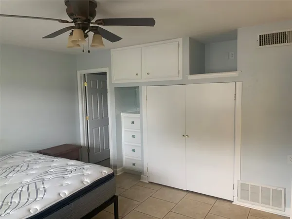 a bedroom with a bed and a chandelier fan
