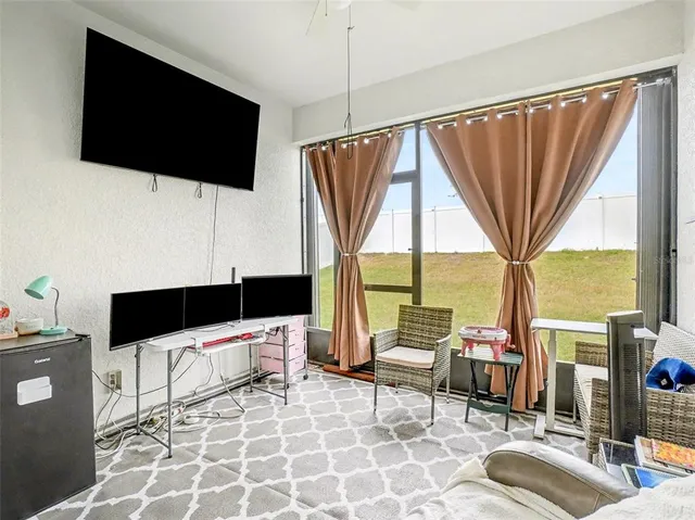 a living room with a flat screen tv and a large window