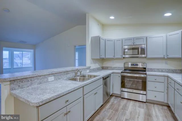 a kitchen with white cabinets stainless steel appliances and sink