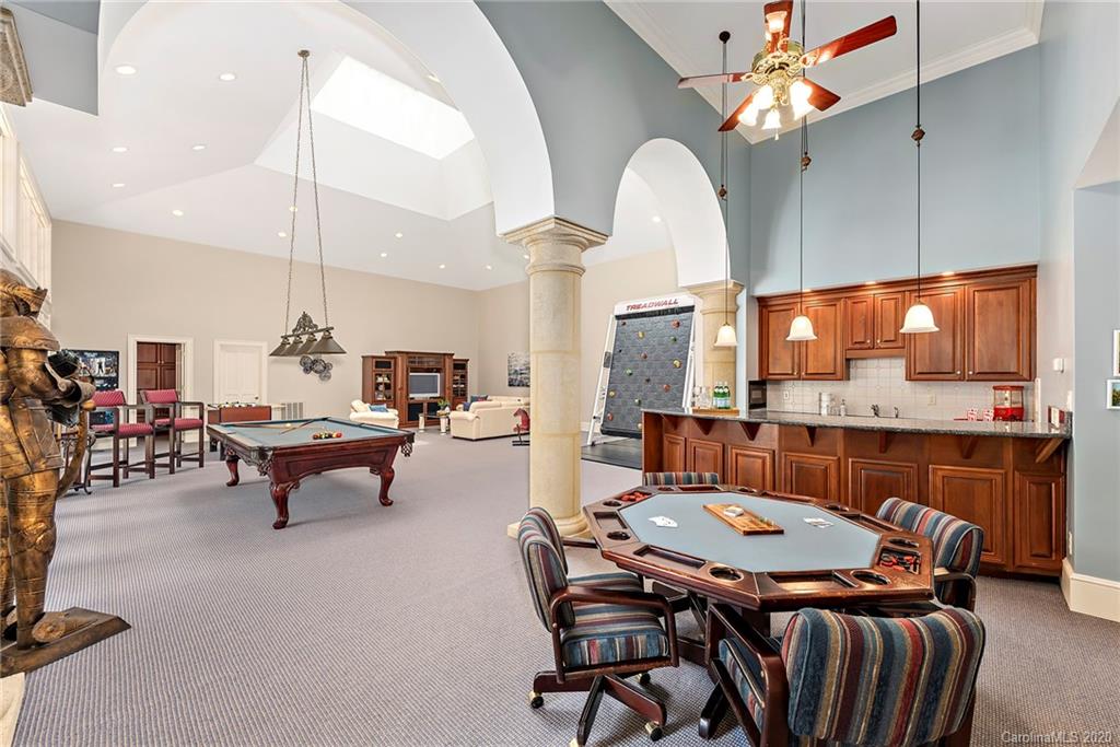 8333 Providence Road Charlotte, NC 28277 - Photo 24 of 47 a living room with furniture a chandelier and a flat screen tv