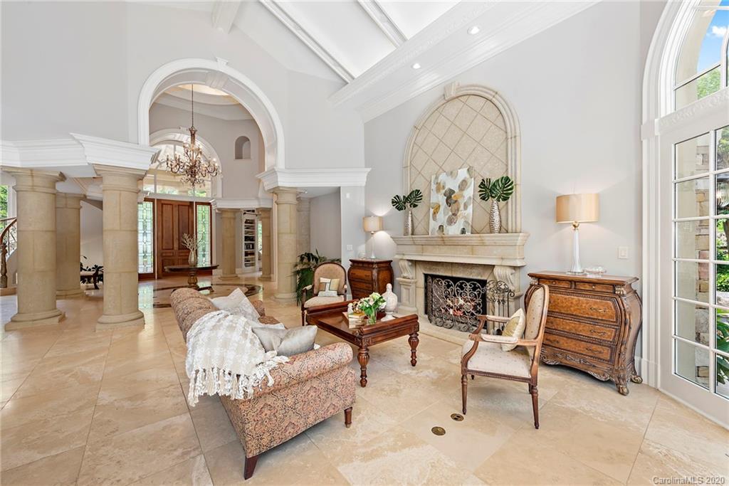 8333 Providence Road Charlotte, NC 28277 - Photo 8 of 47 a living room with furniture a fireplace and a chandelier