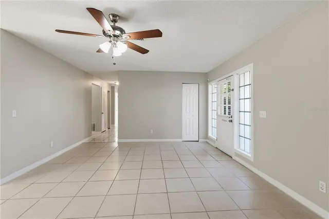 an empty room with fan and windows