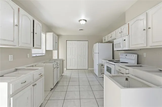 a kitchen with stainless steel appliances granite countertop a stove a refrigerator and a white cabinets