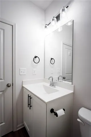 a bathroom with a sink mirror vanity and toilet