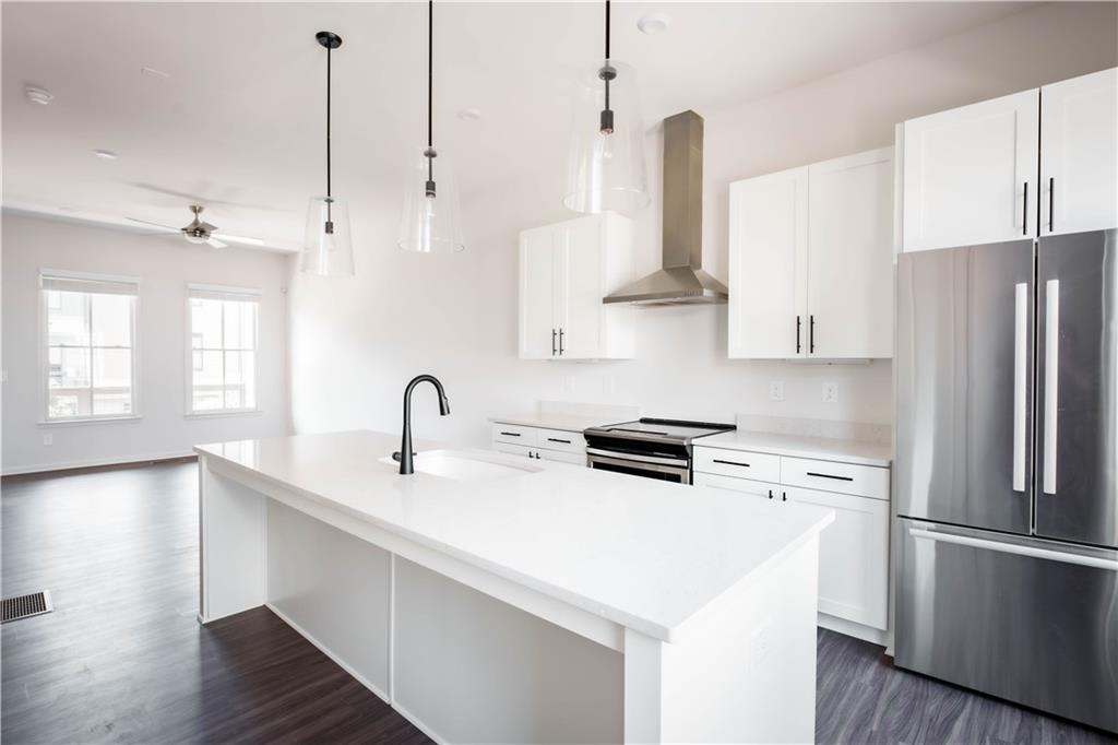 709 Needletail Way Atlanta, GA 30312 - Photo 9 of 29 a kitchen with stainless steel appliances a refrigerator a sink and wooden floors