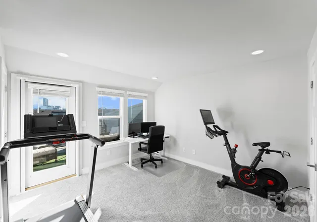 a view of a workspace with furniture and a window