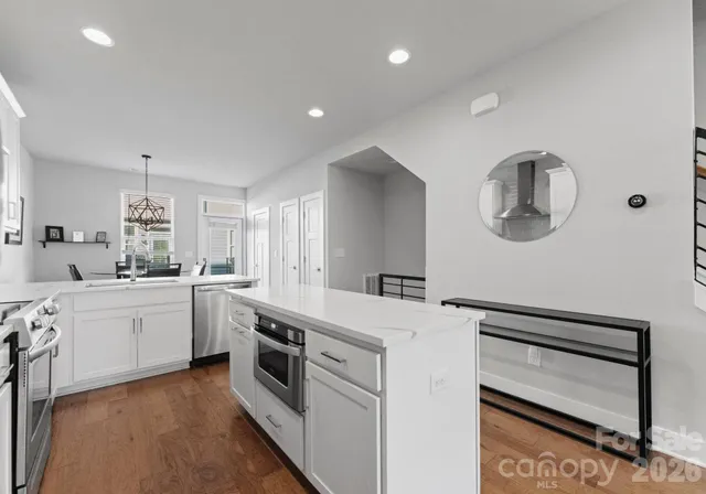 a kitchen with granite countertop white cabinets and white appliances