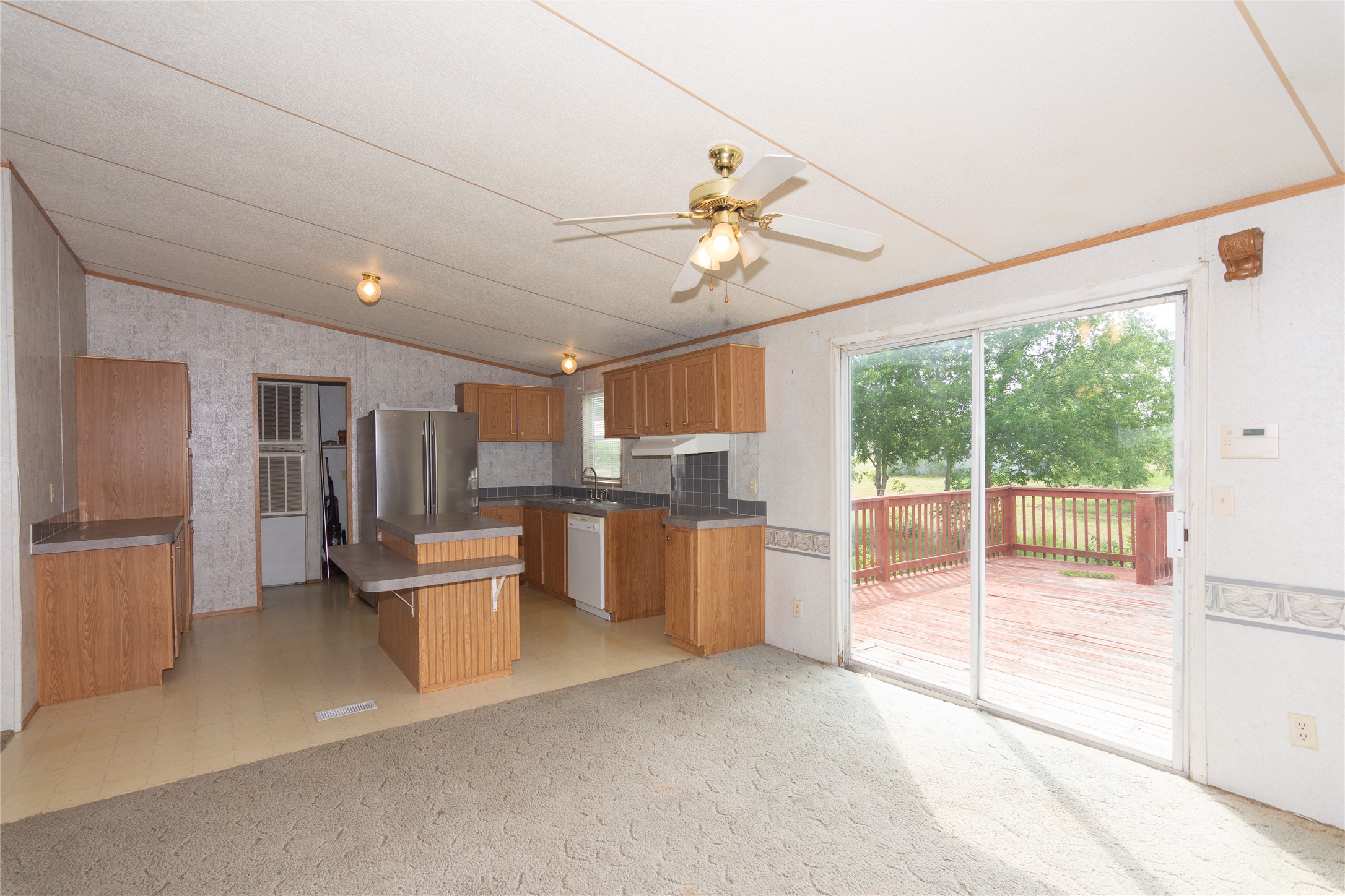 1 11209-tract Road Del Valle, TX 78617 - Photo 11 of 39 Kitchen with freestanding refrigerator, plenty of natural light, brown cabinetry, dishwasher