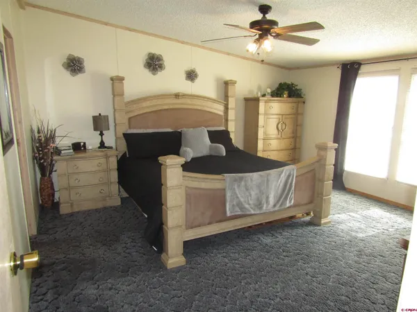 a spacious bedroom with a bed and a chandelier