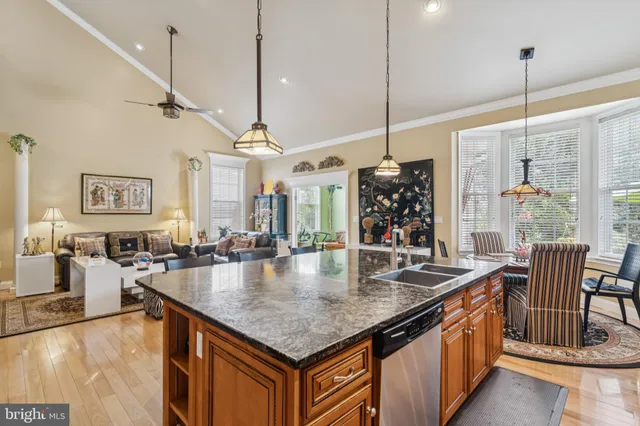 a kitchen with stainless steel appliances granite countertop a table chairs and ocean view
