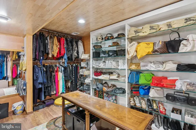 a view of walk in closet with clothes and shoes