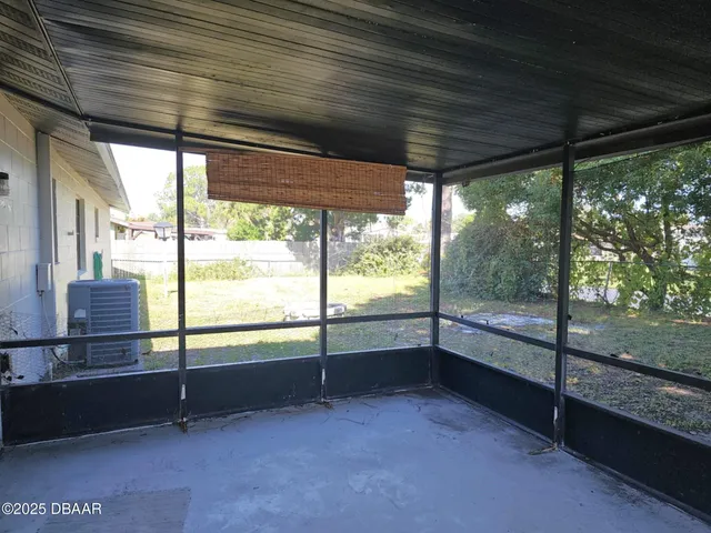 a view of an empty room with wooden floor and a iron gate