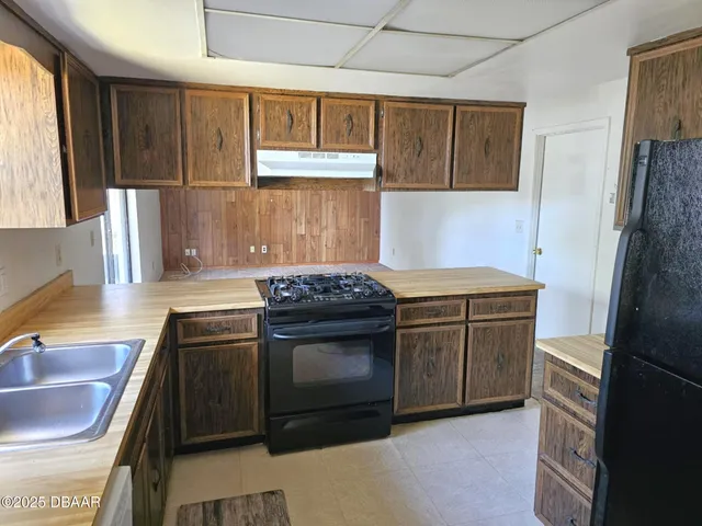 a kitchen with a sink stove and refrigerator