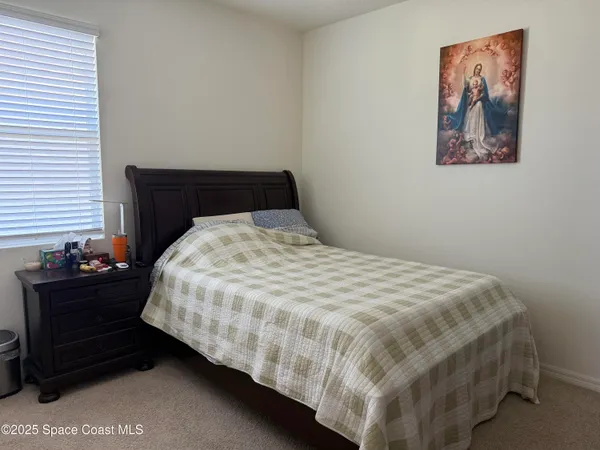 a bedroom with a bed and lamp on dresser