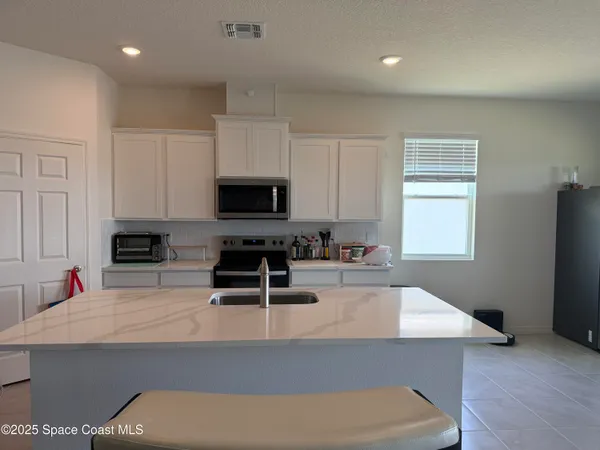 a kitchen with sink refrigerator and microwave