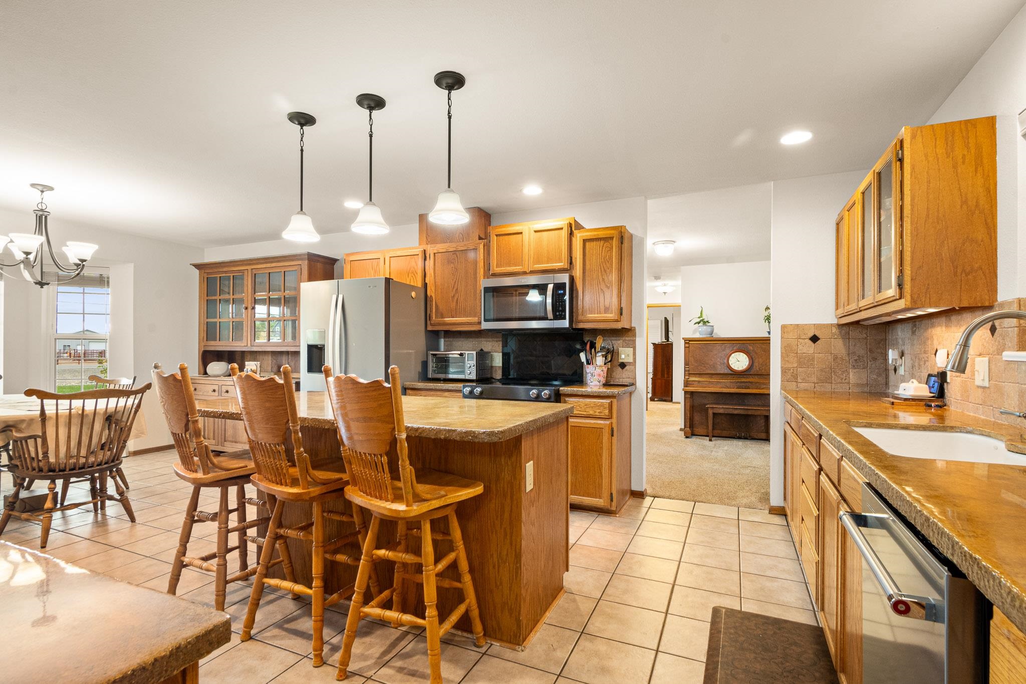 1185-17 17 1/2 Road Fruita, CO 81521 - Photo 12 of 35 a kitchen with stainless steel appliances kitchen island granite countertop a table chairs and a stove