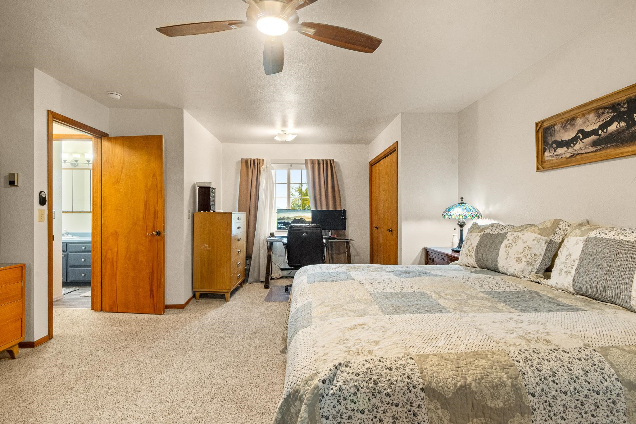 1185-17 17 1/2 Road Fruita, CO 81521 - Photo 26 of 35 a spacious bedroom with a bed and a chandelier