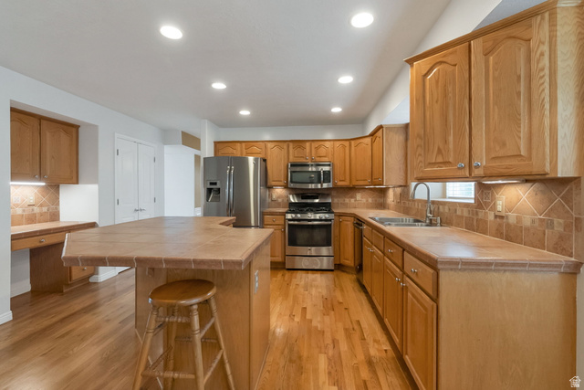 11079 Ohenry Road East Sandy, UT 84070 - Photo 8 of 26 Kitchen featuring wood-finish flooring, recessed lighting, and a kitchen island with tile countertop