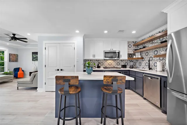 a kitchen with stainless steel appliances a stove a sink cabinets and a refrigerator