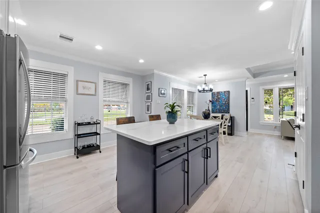 a kitchen with a stove a refrigerator a sink dishwasher with a dining table and chairs with wooden floor