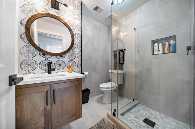 a bathroom with a sink a toilet and a mirror