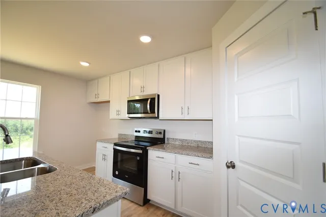 a kitchen with stainless steel appliances granite countertop a stove a sink and a refrigerator