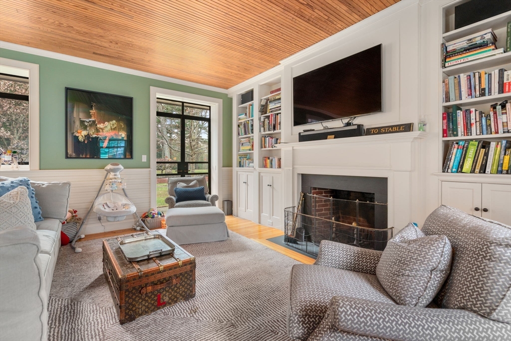 164 Forest Street, Unit 164 Sherborn, MA 01770 - Photo 12 of 32 a living room with furniture a flat screen tv and a fireplace