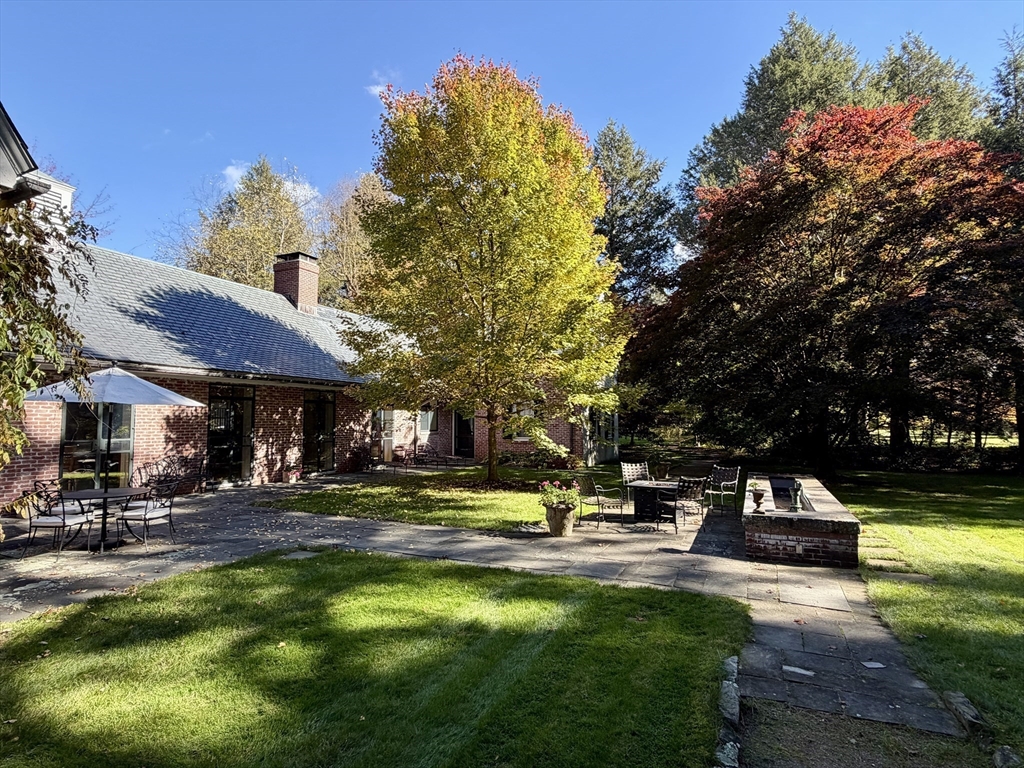 164 Forest Street, Unit 164 Sherborn, MA 01770 - Photo 2 of 32 a view of a swimming pool with lawn chairs under an umbrella