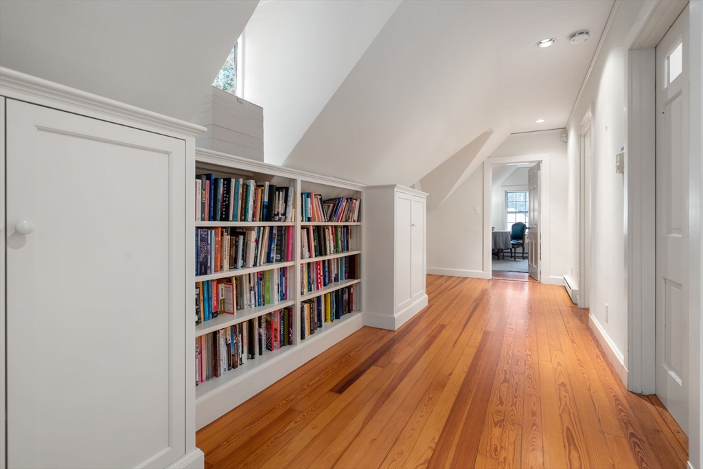 164 Forest Street, Unit 164 Sherborn, MA 01770 - Photo 23 of 32 a view of a book shelf with wooden floor