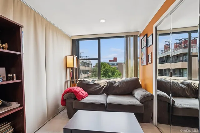 a living room with furniture a flat screen tv and a window