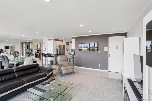 a living room with furniture and a refrigerator