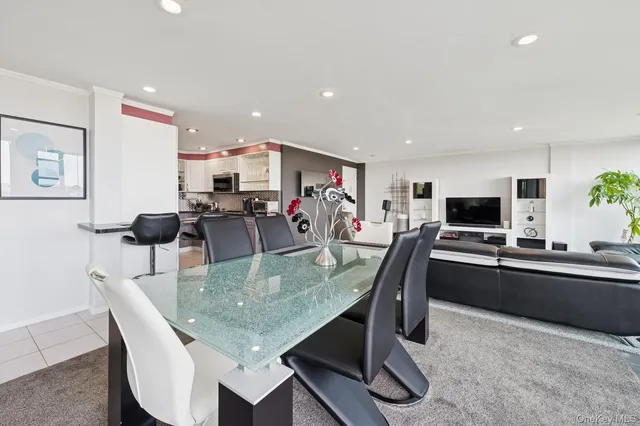 a kitchen with stainless steel appliances granite countertop a table chairs and a refrigerator