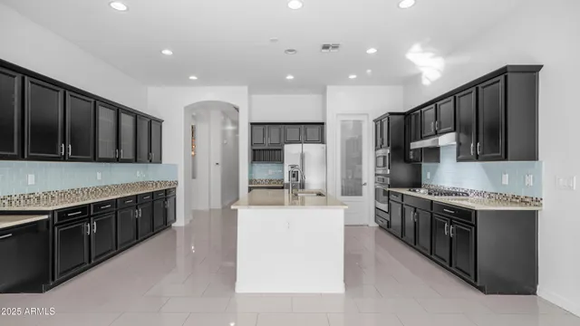 a large kitchen with stainless steel appliances lots of counter top space