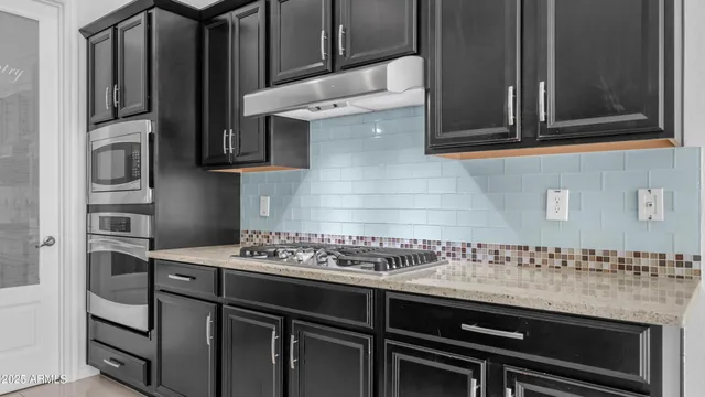 a kitchen with granite countertop a sink and cabinets