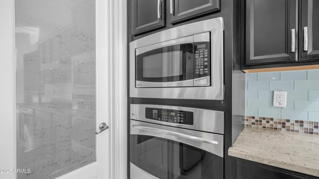 a kitchen with granite countertop white cabinets and stainless steel appliances