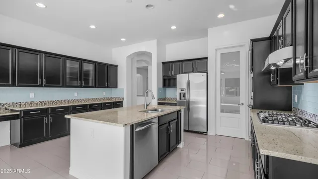 a kitchen with stainless steel appliances granite countertop a stove a refrigerator and a sink