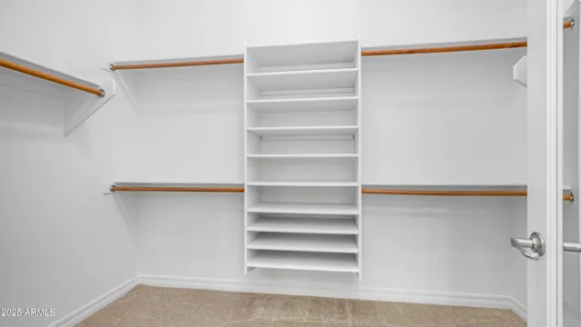 a view of walk in closet with empty racks