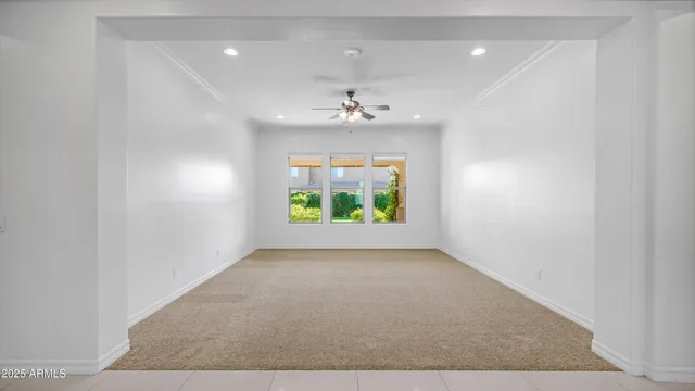an empty room with windows and ceiling fan