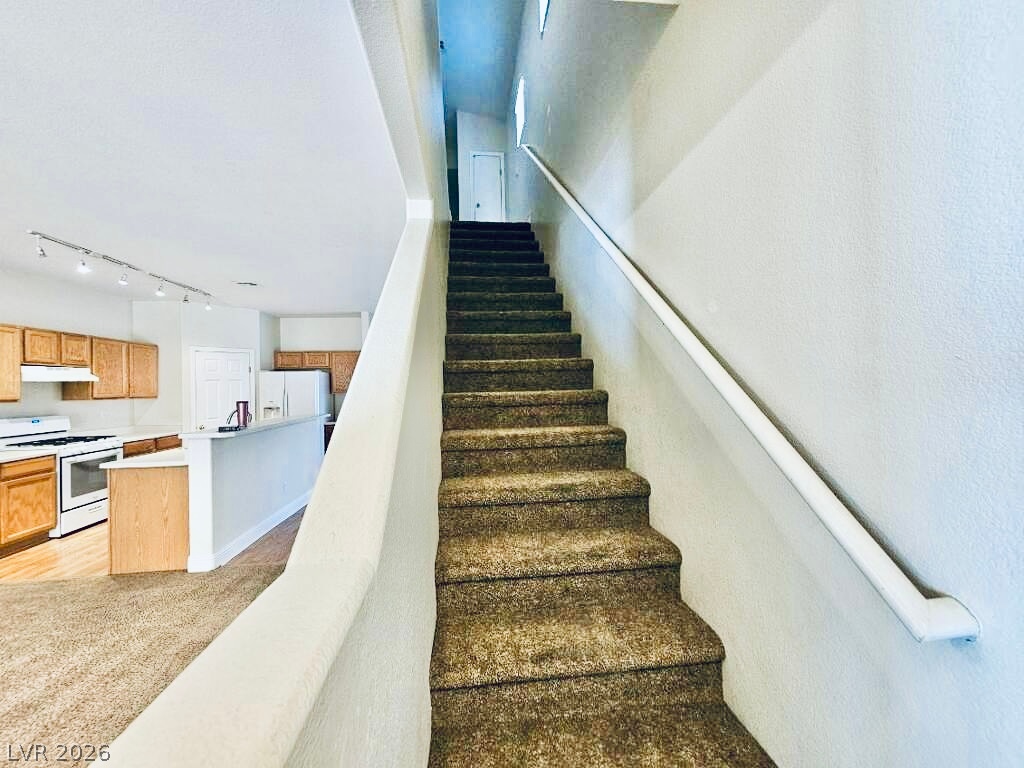 5953 Crumbling Ridge Street Henderson, NV 89011 - Photo 12 of 42 Ascend to comfort with this carpeted staircase, overlooking an open-concept living area.