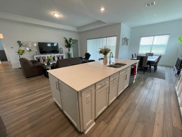 5936 Southwest 90th Court Road Ocala, FL 34481 - Photo 9 of 28 a large white kitchen with wooden floor a sink a dining table and chairs