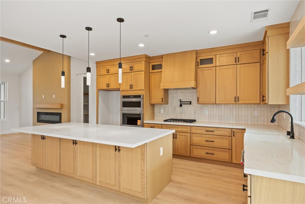 6006 Kibler Road Paradise, CA 95969 - Photo 14 of 43 a large kitchen with stainless steel appliances a stove a sink a refrigerator and white cabinets with wooden floor